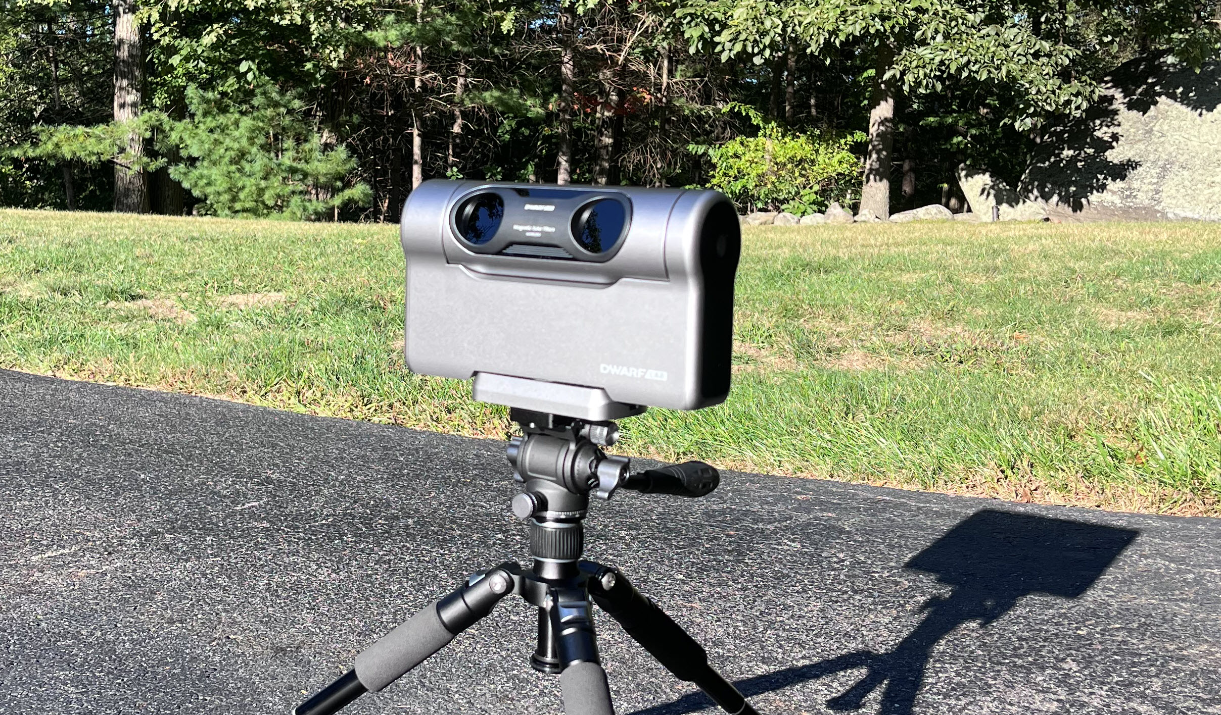 DWARFLab DWARF 3 smart telescope mounted on a tripod outdoors in daylight showing dual lens front panel and compact silver-grey body